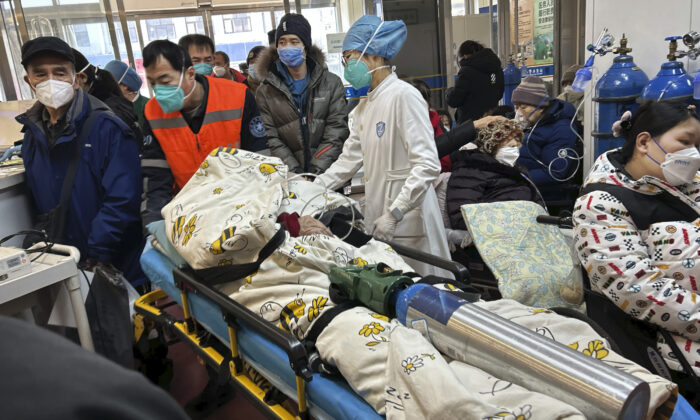 Một bệnh nhân nằm trên băng ca và thở bằng bình oxy được đẩy vào một phòng cấp cứu chật kín tại một bệnh viện ở Bắc Kinh, Trung Quốc, hôm 02/01/2023. (Ảnh: Getty Images)