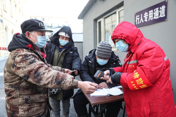 Một nhân viên an ninh đo thân nhiệt của một người đàn ông ở Thẩm Dương, Trung Quốc, vào ngày 02/01/2021. (Ảnh: STR/AFP qua Getty Images)