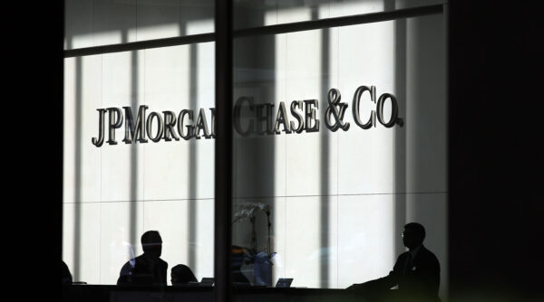 Mọi người đi ngang qua một tấm biển có dòng chữ JPMorgan Chase & Co. tại trụ sở chính của ngân hàng này ở Manhattan, thành phố New York, vào ngày 02/10/2012. (Ảnh: Spencer Platt/Getty Images)