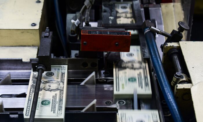 Trong ảnh, các gói tờ 20 USD mới in được xử lý để đóng gói tại Cục Ấn loát của Bộ Ngân khố Hoa Kỳ ở Hoa Thịnh Đốn. (Ảnh: Eva Hambach/AFP qua Getty Images)