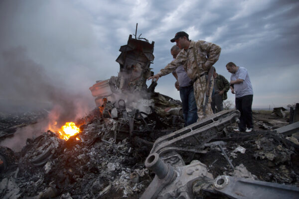 Mọi người kiểm tra hiện trường vụ rơi phi cơ chở khách gần làng Grabovo, Ukraine, vào ngày 17/07/2014. (Ảnh: Dmitry Lovetsky/AP Photo)
