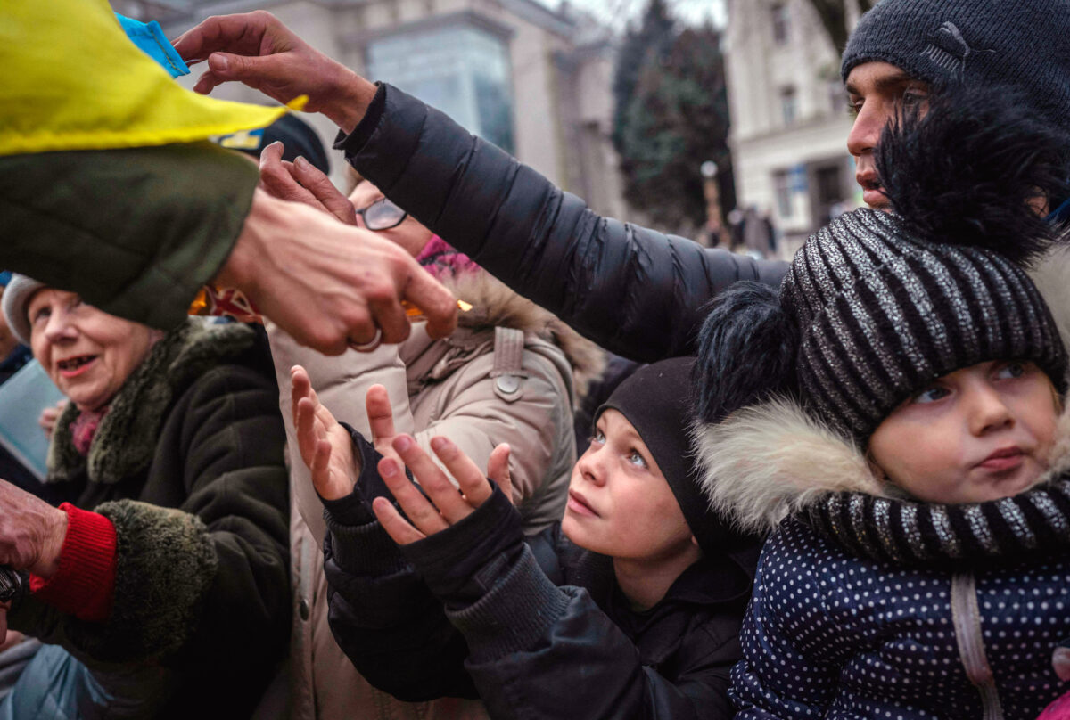 Một đứa trẻ nhận viện trợ ở Kherson, Ukraine, hôm 18/11/2022, sau khi gần một nửa cơ sở hạ tầng năng lượng của đất nước này bị vô hiệu hóa do các cuộc tấn công của Nga, khiến khoảng 10 triệu người Ukraine không có điện. (Ảnh: Bulent Kilic/AFP qua Getty Images)