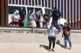 Công dân Venezuela đi dọc hàng rào biên giới tới chỗ một chiếc xe tải của Lực lượng Tuần tra Biên giới đang đợi sau khi vượt sông Rio Grande trái phép từ Mexico, ở El Paso, Texas, hôm 21/09/2022. (Ảnh: Joe Raedle/Getty Images)