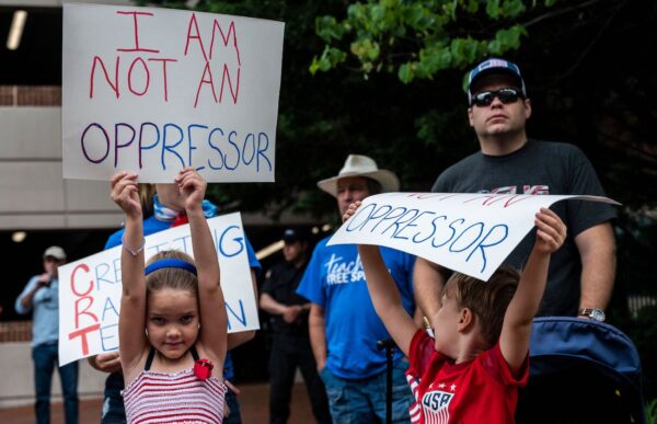 Người dân giơ cao các biển phản đối thuyết chủng tộc trọng yếu (CRT) đang được giảng dạy trong các trường học trong một cuộc biểu tình tại Trung tâm Chính phủ Quận Loudoun ở Leesburg, Virginia, ngày 12/06/2021. (Ảnh: Andrew Caballero-Reynolds/AFP qua Getty Images)