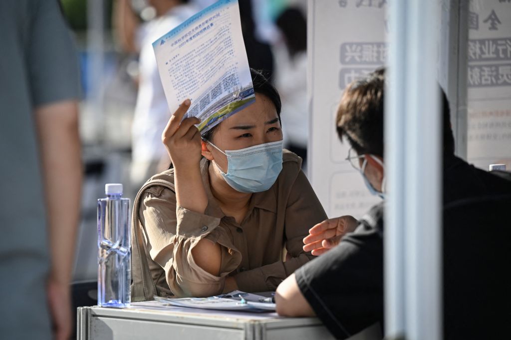 Một người tìm việc nói chuyện với một nhà tuyển dụng tại một hội chợ việc làm ở Bắc Kinh hôm 26/08/2022. (Ảnh: Jade Gao/AFP qua Getty Images)