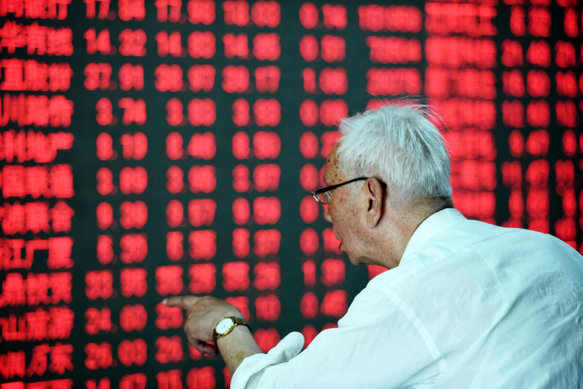 Một nhà đầu tư Trung Quốc chỉ tay trước một màn hình hiển thị diễn biến thị trường chứng khoán tại một công ty chứng khoán ở Hàng Châu, tỉnh Chiết Giang phía đông Trung Quốc vào ngày 31/05/2016. (Ảnh: STR/AFP qua Getty Images)