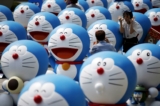 Một người đàn ông chụp ảnh bạn gái của mình tạo dáng bên cạnh nhân vật Doraemon trong một cuộc triển lãm ở Seoul, Nam Hàn, ngày 31/08/2015. (Ảnh: Kim Hong-Ji/Reuters)