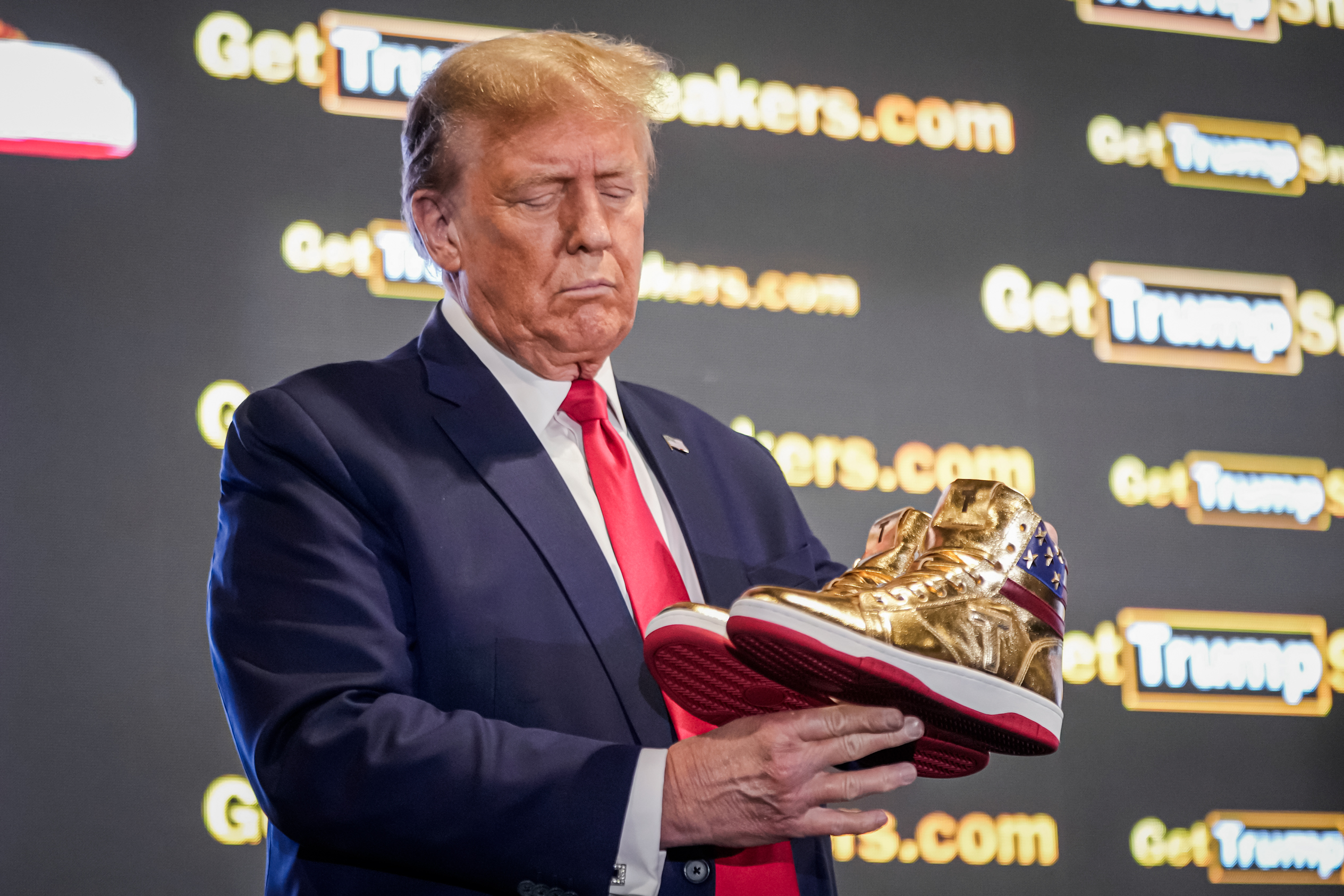 Cựu Tổng thống Donald Trump cầm đôi giày thể thao Trump màu vàng kim tại Sneaker Con ở Philadelphia, hôm 17/02/2024. (Ảnh: Manuel Balce Ceneta/AP Photo)