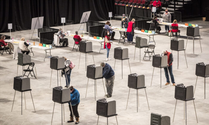 Cử tri tiến hành điền thông tin và bỏ phiếu tại địa điểm bỏ phiếu Trung tâm Bảo hiểm Cross, nơi toàn thành phố bỏ phiếu ở Bangor, Maine, vào ngày 03/11/2020. (Ảnh: Scott Eisen/Getty Images)