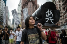 Ông Lương Quốc Hùng (Leung Kwok-hung), được biết đến với biệt danh “Tóc Dài,” giúp khiêng một chiếc quan tài giả khi tham dự một cuộc biểu tình ở Hồng Kông vào ngày 31/05/2015, để kỷ niệm cuộc đàn áp năm 1989 tại Quảng trường Thiên An Môn ở Bắc Kinh, trước lễ kỷ niệm 26 năm vụ việc này xảy ra vào ngày 04/06. (Ảnh: Anthony Wallace/AFP qua Getty Images)