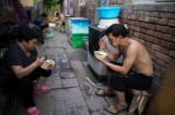 Người ăn tối trên đường phố trong một làng di cư ở vùng ngoại ô Bắc Kinh, ngày 17/08/2017. (Ảnh: Nicolas Asfouri/AFP/Getty Images)
