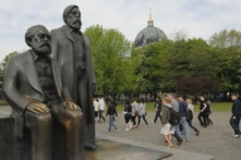 Du khách đi ngang qua bức tượng của Karl Marx (1818–1883) và Friedrich Engels (1820–1895) ở trung tâm thủ đô Berlin ngày 28/04/2009. (Ảnh: Theo Heimann /DDP/AFP via Getty Images)