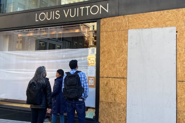 Du khách ghé thăm Quảng trường Union Square đang nhìn vào một cửa hàng Louis Vuitton bị hư hại ở San Francisco vào ngày 21/11/2021. (Ảnh: Danielle Echeverria/San Francisco Chronicle qua AP)