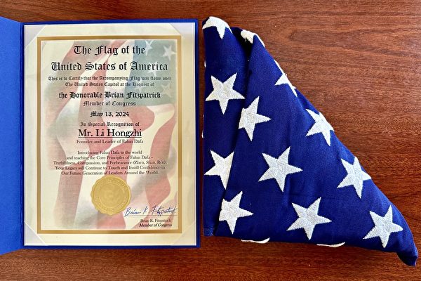 Nghị sĩ Hoa Kỳ Brian Fitzpatrick đến từ tiểu bang Pennsylvania đã trao tặng một lá cờ và thư khen ngợi cho học viên Pháp Luân Công Jennie Sheeks để chúc mừng ngày Pháp Luân Đại Pháp Thế giới, cũng như để tỏ lòng kính trọng đối với Đại Sư Lý Hồng Chí, nhà sáng lập Pháp Luân Công. (Ảnh: Đăng dưới sự cho phép của Jennie Sheeks)