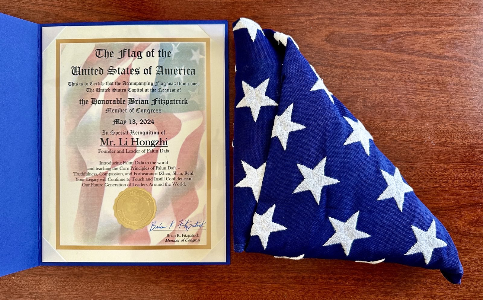 Nghị sĩ Hoa Kỳ Brian Fitzpatrick của tiểu bang Pennsylvania đã trao tặng một lá cờ và thư khen ngợi cho học viên Pháp Luân Công Jennie Sheeks để chúc mừng ngày Pháp Luân Đại Pháp Thế Giới, cũng như để tỏ lòng kính trọng đối với Đại Sư Lý Hồng Chí, nhà sáng lập Pháp Luân Công. (Ảnh: Đăng dưới sự cho phép của cô Jennie Sheeks)