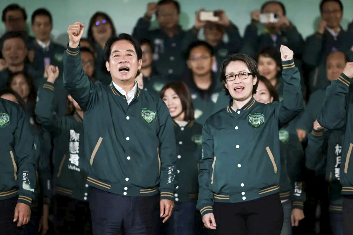 Tổng thống đắc cử Đài Loan Lại Thanh Đức (trái) ra hiệu bên cạnh ứng cử viên liên danh Tiêu Mỹ Cầm trong một mít tinh bên ngoài trụ sở của Đảng Dân chủ Tiến bộ (DPP) ở Đài Bắc, hôm 13/01/2024. (Ảnh: Yasuyoshi Chiba/AFP qua Getty Images)