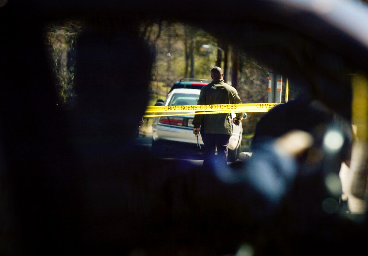 Ảnh tư liệu cho thấy một người lái xe đang đi chậm lại để quan sát các nhân viên chấp pháp tại hiện trường vụ án ở Atlanta, Georgia, vào ngày 12/03/2005. (Ảnh: Davis Turner/Getty Images)