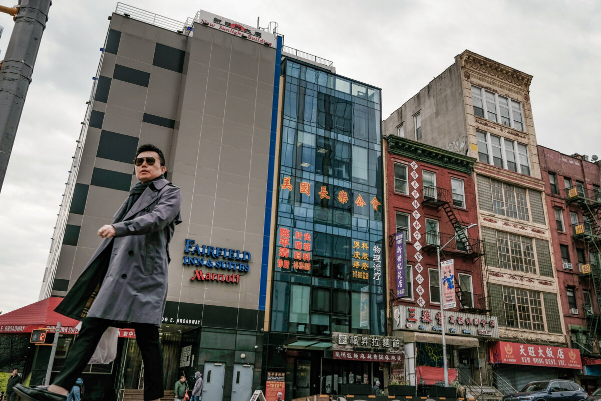Người dân đi ngang qua tòa nhà (ở giữa) bị nghi là đồn công an chìm do Bắc Kinh kiểm soát, dùng để đàn áp những người bất đồng chính kiến ​​sống ở Hoa Kỳ, tại Khu Phố Tàu của thành phố New York, hôm 18/04/2023. (Ảnh: Spencer Platt/Getty Images)