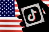 Logo của ứng dụng mạng xã hội TikTok hiển thị trên màn hình một chiếc iPhone trên nền quốc kỳ Mỹ ở Arlington, Virginia, ngày 03/08/2020. (Ảnh: Olivier Douliery/AFP qua Getty Images)
