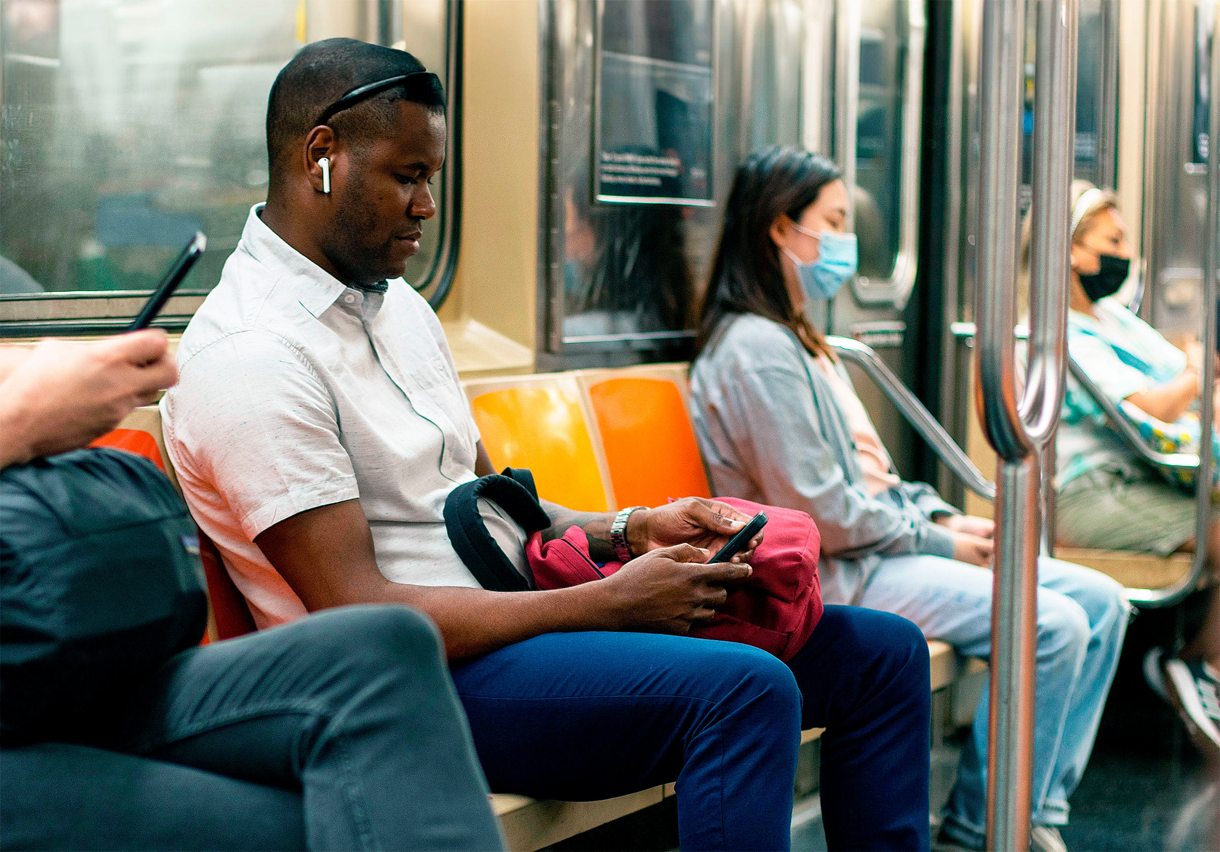 Hành khách dùng điện thoại di động trên tàu điện ngầm ở thành phố New York. (Ảnh: Tada Images/Shutterstock)
