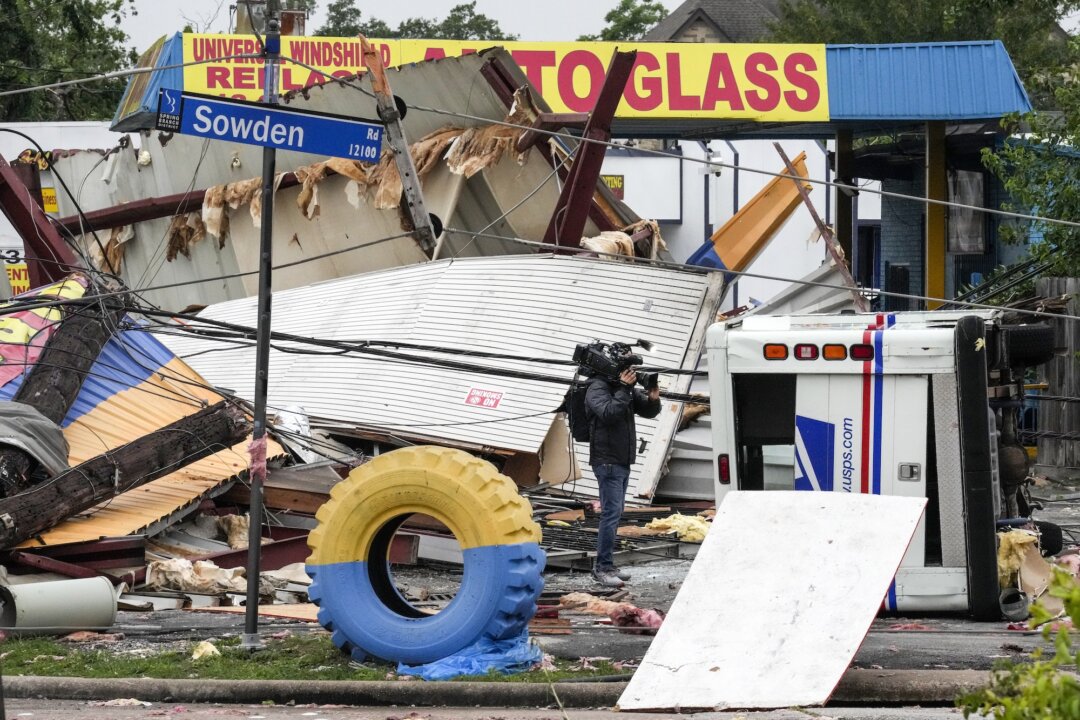 Một ký giả đang quay cảnh thiệt hại tại một cửa hàng lốp xe sau cơn bão dữ dội ở Houston, Texas, hôm 17/05/2024. (Ảnh: Brett Coomer/Houston Chronicle qua AP)