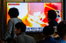 Người dân đi ngang qua một chiếc tivi đang chiếu đoạn phim tư liệu trong một bản tin thời sự tại một nhà ga xe lửa ở Seoul hôm 28/05/2024, sau khi tối muộn hôm thứ Hai, Bắc Hàn cho biết hỏa tiễn mang theo vệ tinh do thám “Malligyong-1-1” của họ đã phát nổ sau khi phóng vài phút do nghi ngờ có vấn đề về động cơ. (Ảnh: Anthony Wallace/AFP qua Getty Images)