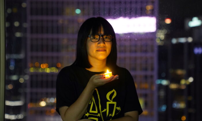 Bà Chow Hang Tung, nữ phó chủ tịch Liên minh Hồng Kông Ủng hộ các Phong trào Dân chủ Yêu nước của Trung Quốc, tại Hồng Kông, vào ngày 03/06/2021, chụp ảnh cùng với một cây nến trước ngày tưởng niệm 32 năm vụ thảm sát những người biểu tình ủng hộ dân chủ tại Quảng trường Thiên An Môn, Bắc Kinh, vào năm 1989. (Ảnh: Lam Yik/Reuters)