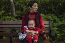 Một người phụ nữ bế một đứa trẻ tại một công viên ở Bắc Kinh, Trung Quốc hôm 12/05/2021. (Ảnh: Kevin Frayer/Getty Images)