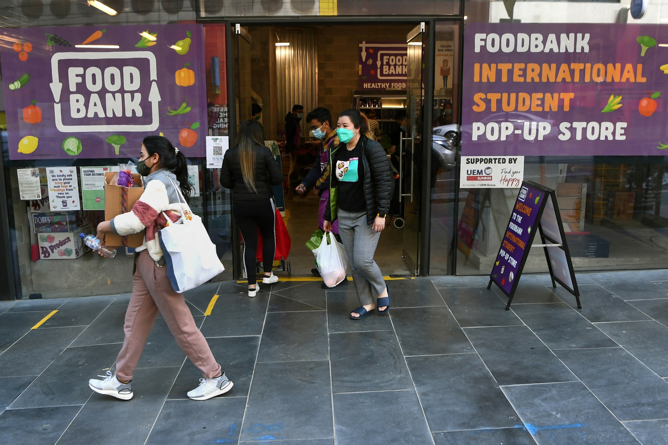 Sinh viên quốc tế mang theo hàng tạp phẩm từ một ngân hàng thực phẩm ở Melbourne, Úc vào ngày 13/08/2021. (Ảnh: William West/AFP qua Getty Images)