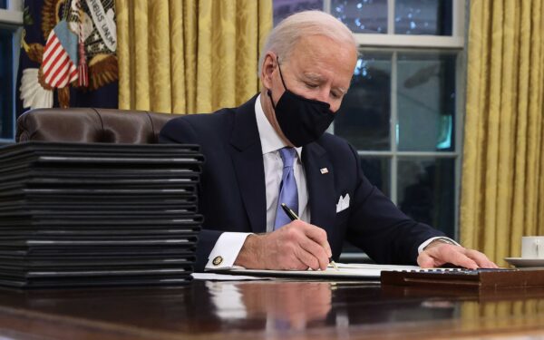 Tổng thống Joe Biden ký một loạt sắc lệnh tại Bàn Kiên định trong Phòng Bầu dục, chỉ vài giờ sau khi ông nhậm chức ở Hoa Thịnh Đốn, ngày 20/01/2021. (Ảnh: Chip Somodevilla/Getty Images)