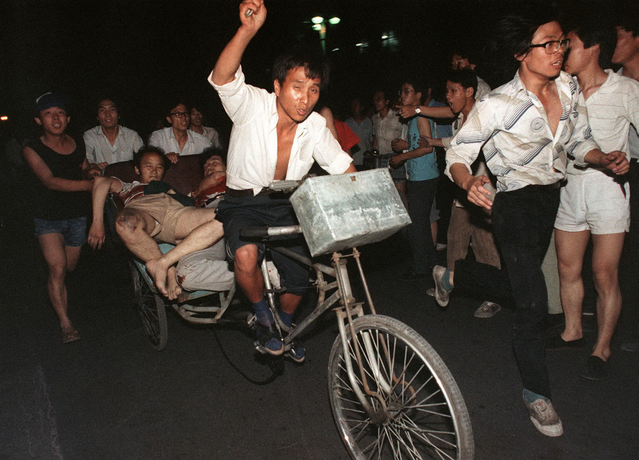 Vào đêm ngày 04/06/1989, quân đội của ĐCSTQ đã nổ súng vào người dân gần Quảng trường Thiên An Môn ở Bắc Kinh. Ảnh chụp những sinh viên bị thương được đưa khỏi quảng trường nhờ xe ba bánh. (Ảnh: Manuel Ceneta/AFP)