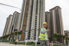 Một công nhân đi ngang qua một khu chung cư do nhà phát triển địa ốc Trung Quốc Evergrande xây dựng ở Vũ Hán, tỉnh Hồ Bắc, miền trung Trung Quốc, vào ngày 28/09/2023. (Ảnh: STR/AFP qua Getty Images)