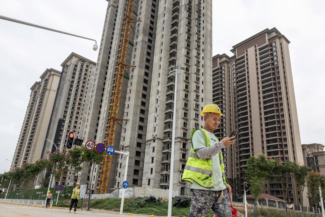 Một công nhân đi ngang qua một khu chung cư do nhà phát triển địa ốc Trung Quốc Evergrande xây dựng ở Vũ Hán, tỉnh Hồ Bắc, miền trung Trung Quốc, vào ngày 28/09/2023. (Ảnh: STR/AFP qua Getty Images)