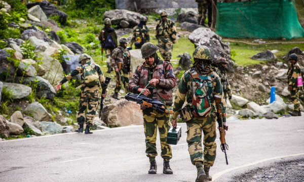 Quân đội của Lực lượng An ninh Biên giới Ấn Độ tuần tra khi một đoàn xe của quân đội Ấn Độ đi qua trên một xa lộ dẫn tới Leh, giáp biên giới Trung Quốc, ở Gagangir, Ấn Độ, vào ngày 19/06/2020. (Ảnh: Yawar Nazir/Getty Images)