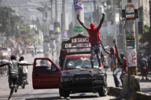 Một người đàn ông bịt mặt kêu gọi mọi người dừng lại trong cuộc biểu tình phản đối chính phủ Thủ tướng Ariel Henry ở Port-au-Prince, Haiti, hôm 01/03/2024. (Ảnh: Ralph Tedy Erol/Reuters)
