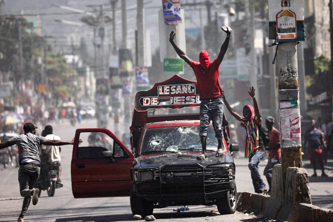 Một người đàn ông bịt mặt kêu gọi mọi người dừng lại trong cuộc biểu tình phản đối chính phủ Thủ tướng Ariel Henry ở Port-au-Prince, Haiti, hôm 01/03/2024. (Ảnh: Ralph Tedy Erol/Reuters)
