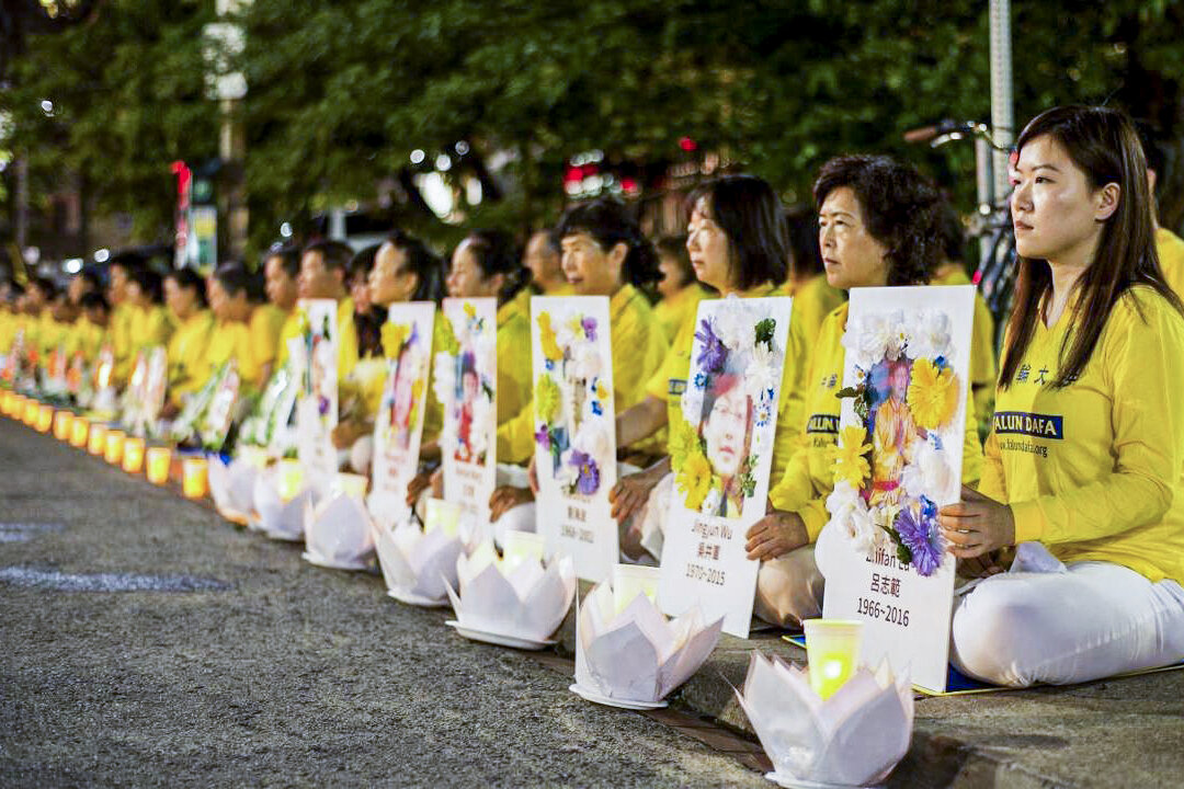 Các học viên Pháp Luân Công tham gia buổi thắp nến tưởng niệm, cầm ảnh của các học viên đã thiệt mạng trong cuộc đàn áp ở Trung Quốc, trước Lãnh sự quán Trung Quốc ở Toronto vào ngày 13/07/2019. (Ảnh: The Epoch Times)