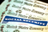 Thẻ An sinh Xã hội nằm cạnh những tấm chi phiếu từ Bộ Ngân khố Hoa Kỳ ở Hoa Thịnh Đốn, ngày 14/10/2021. (Ảnh: Kevin Dietsch/Getty Images)