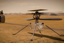 Trực thăng Ingenuity Mars của NASA đứng trên bề mặt Hành tinh Đỏ khi tàu thăm dò Mars 2020 Perseverance của NASA (có thể nhìn thấy một phần ở bên trái) chuyển bánh rời đi. (Ảnh: NASA qua Getty Images)
