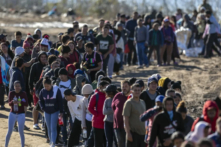 Hơn một ngàn người nhập cư bất hợp pháp xếp hàng chờ để được các nhân viên Tuần tra Biên giới Hoa Kỳ giải quyết ở Eagle Pass, Texas sau khi vượt sông Rio Grande từ Mexico, hôm 18/12/2023. (Ảnh: John Moore/Getty Images)