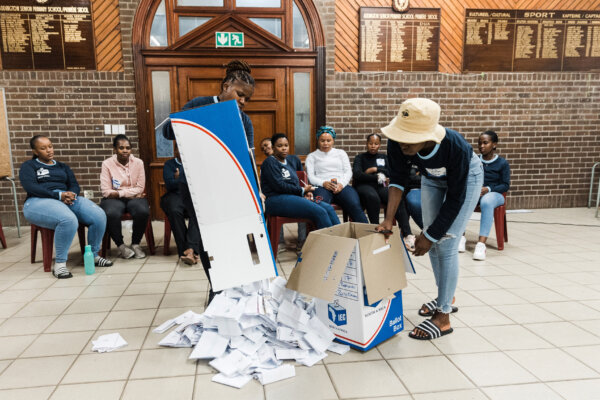 Các viên chức Ủy ban Bầu cử Nam Phi đổ các lá phiếu ra khỏi thùng phiếu trong quá trình kiểm đếm phiếu tại trạm bỏ phiếu ở Trường tiểu học Addton trong cuộc tổng tuyển cử của Nam Phi ở Durban, Nam Phi, hôm 29/05/2024. (Ảnh: Rajesh Jantilal/AFP qua Getty Images)