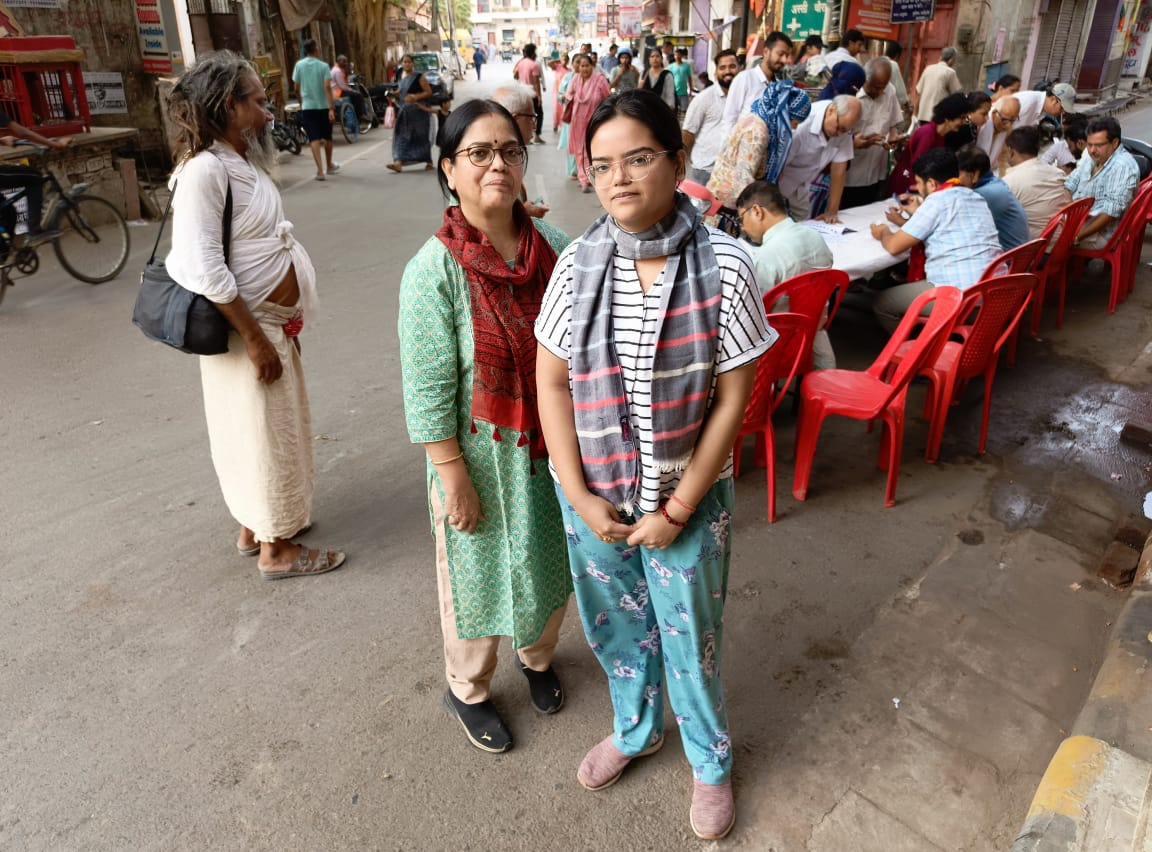 Cô Anushya Sinha, 26 tuổi, lần đầu tiên đi bầu cử, đứng cùng mẹ tại một điểm bỏ phiếu ở Assi Ghat, Ấn Độ, hôm 01/06/2024. (Ảnh: Venus Upadhayaya/The Epoch Times)