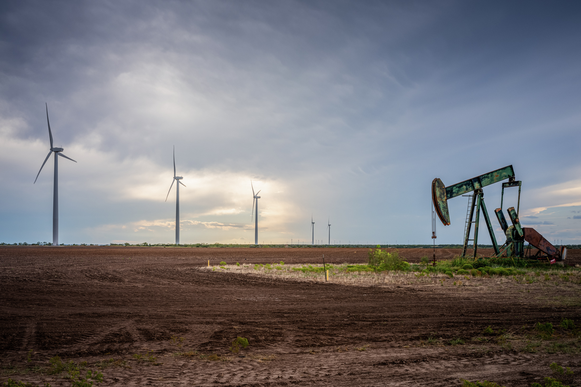 Một máy bơm dầu ở gần cánh đồng tuabin gió ở Nolan, Texas, vào ngày 04/10/2023. (Ảnh: Brandon Bell/Getty Images