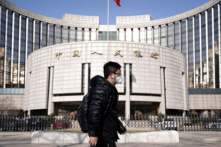 Một người đeo khẩu trang đi ngang qua trụ sở Ngân hàng Nhân dân Trung Quốc, ngân hàng trung ương của Trung Quốc, tại Bắc Kinh, Trung Quốc, ngày 03/02/2020. (Ảnh: Jason Lee/Reuters)