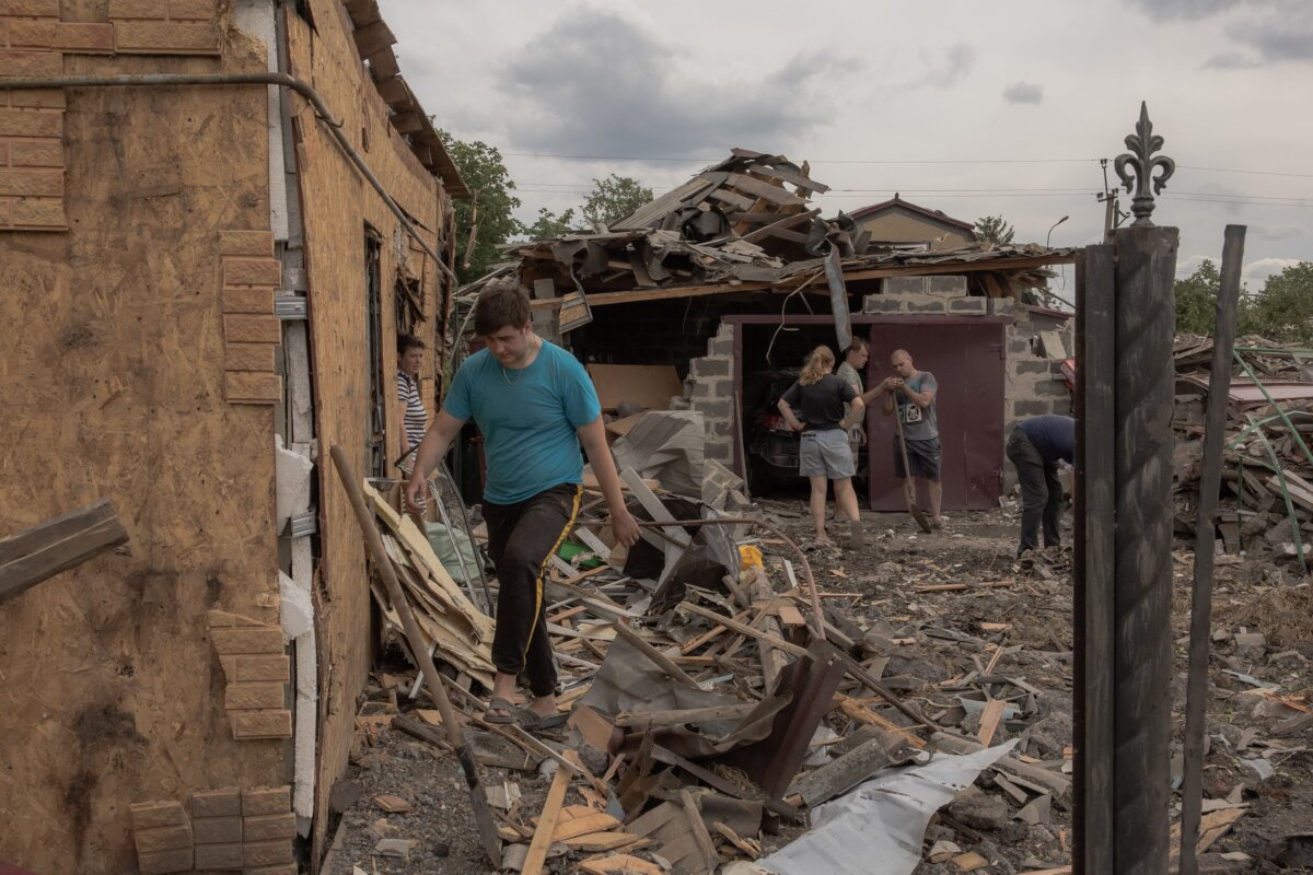 Người dân dọn dẹp các mảnh vỡ bên cạnh những ngôi nhà bị hư hại nặng sau trận pháo kích ở Pokrovsk, thuộc phía đông vùng Donetsk của Ukraine, hôm 24/06/2024. (Ảnh: Roman Pilipey/AFP qua Getty Images)