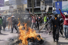 Người biểu tình tập trung bên cạnh những chiếc lốp xe bị đốt cháy trong một cuộc biểu tình phản đối dự luật tài chính ở Nairobi, Kenya, hôm 25/06/2024. (Ảnh: Patrick Meinhardt/Getty Images)
