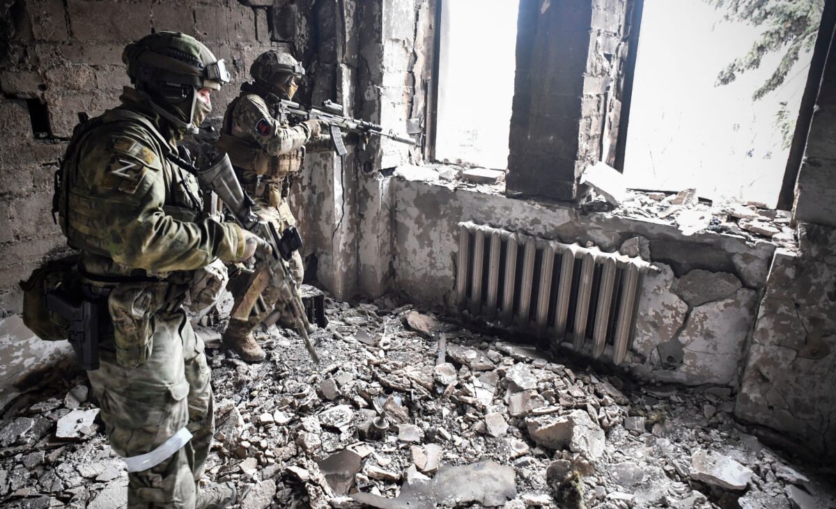 Hai quân nhân Nga tuần tra tại nhà hát kịch Mariupol, địa điểm bị đánh bom hôm 16/03, ở Mariupol, Ukraine, vào ngày 12/04/2022. (Ảnh: Alexander Nemenov/AFP qua Getty Images)