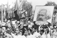 Trong một bức ảnh tư liệu, những thanh niên có mặt tại một cuộc tập hợp trong thời kỳ cao điểm của cuộc biến động Hồng Vệ Binh giơ cao bản sao các bài viết được sưu tầm của Chủ tịch Đảng Cộng sản Mao Trạch Đông, thường được gọi là Tiểu Hồng Thư của Mao, và mang theo một tấm bích chương hình Karl Marx. (Ảnh: AP Photo, Tư liệu)