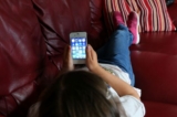 Một em nhỏ sử dụng điện thoại thông minh Apple trong ảnh tư liệu không ghi ngày tháng này. (Ảnh: PA)