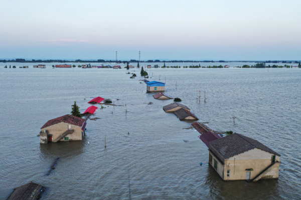 Vỡ đập tại hồ Động Đình vào tối 05/07/2024, nước lũ tràn qua mái nhà, người dân phải sơ tán trong đêm. Hình ảnh nhà dân bị ngập lụt tại huyện Hoa Dung, tỉnh Hồ Nam được chụp vào hôm 07/07/2024. (Ảnh: Stringer/AFP)